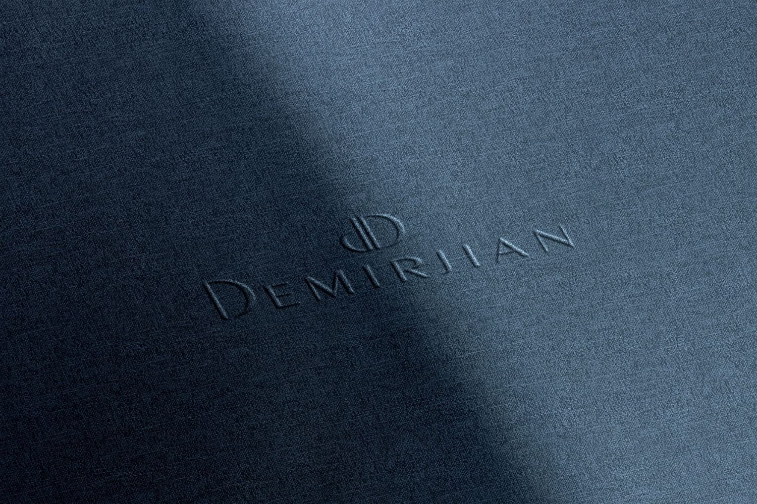 Embossed 'Demirlian' logo on a textured blue surface.