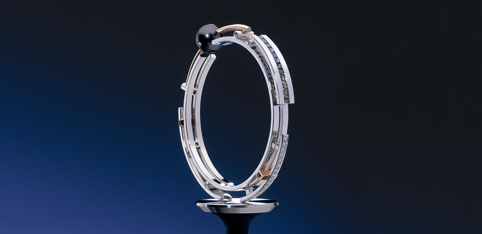 Elegant luxury black pearl bracelet by Garo Demirjian, set in 18k white and rose gold with diamond accents, displayed on a dark blue background.