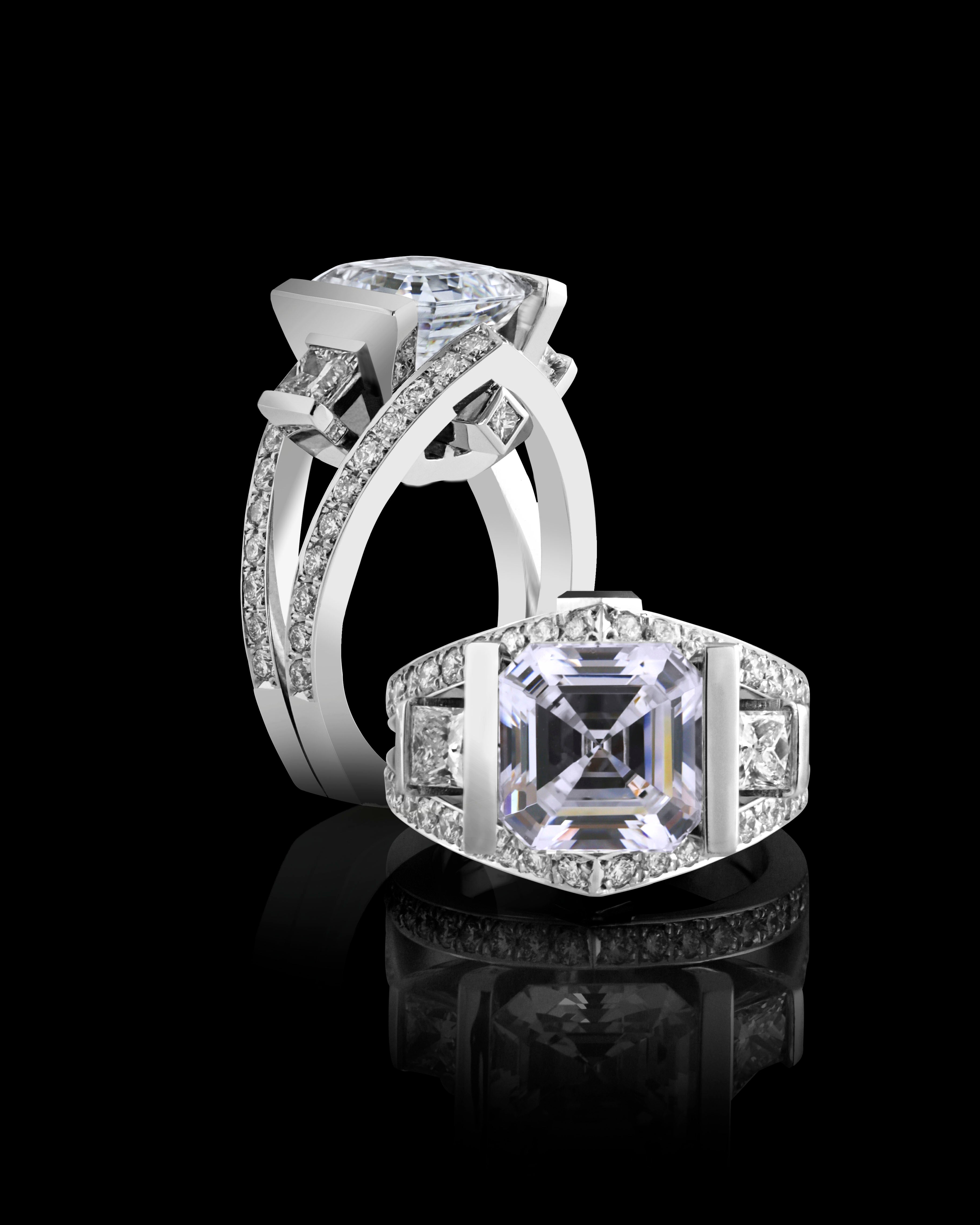 An elegant ring featuring a central square-cut diamond flanked by smaller stones on a reflective surface against a black background.