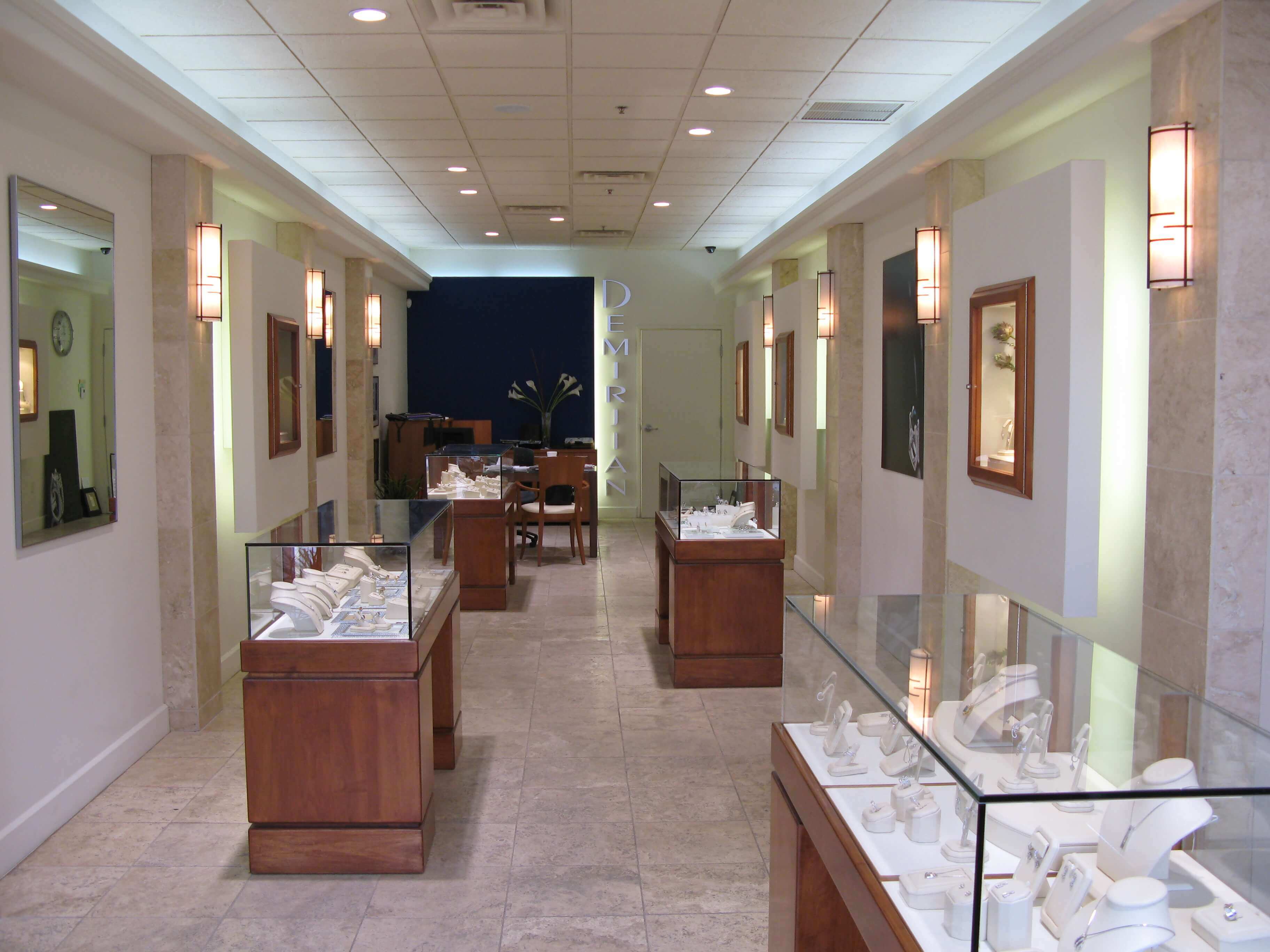 A long hallway with a variety of jewelry on display in glass cases.