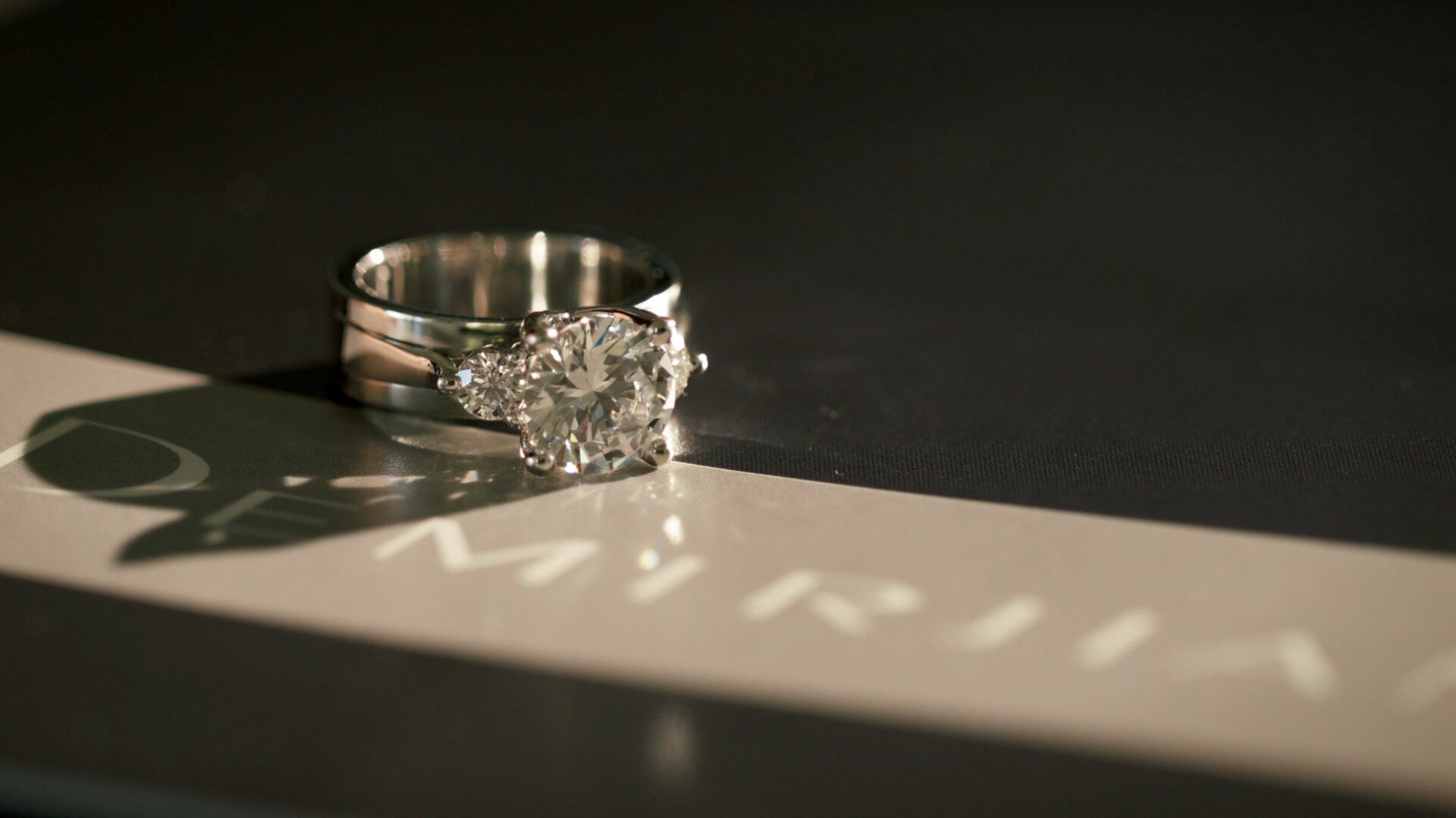A diamond ring from Demirjian Jewelry Design, sitting on a table.