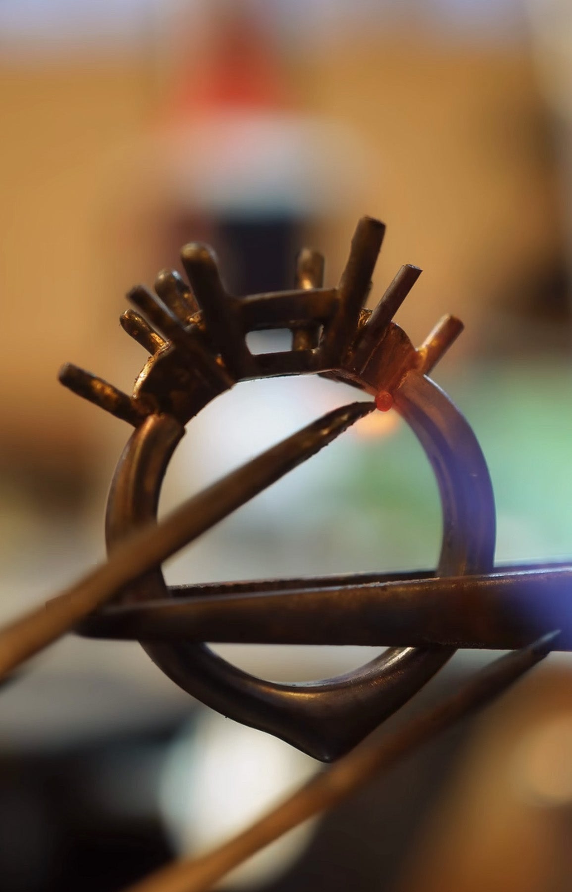 Close-up of a jeweler soldering a ring setting.