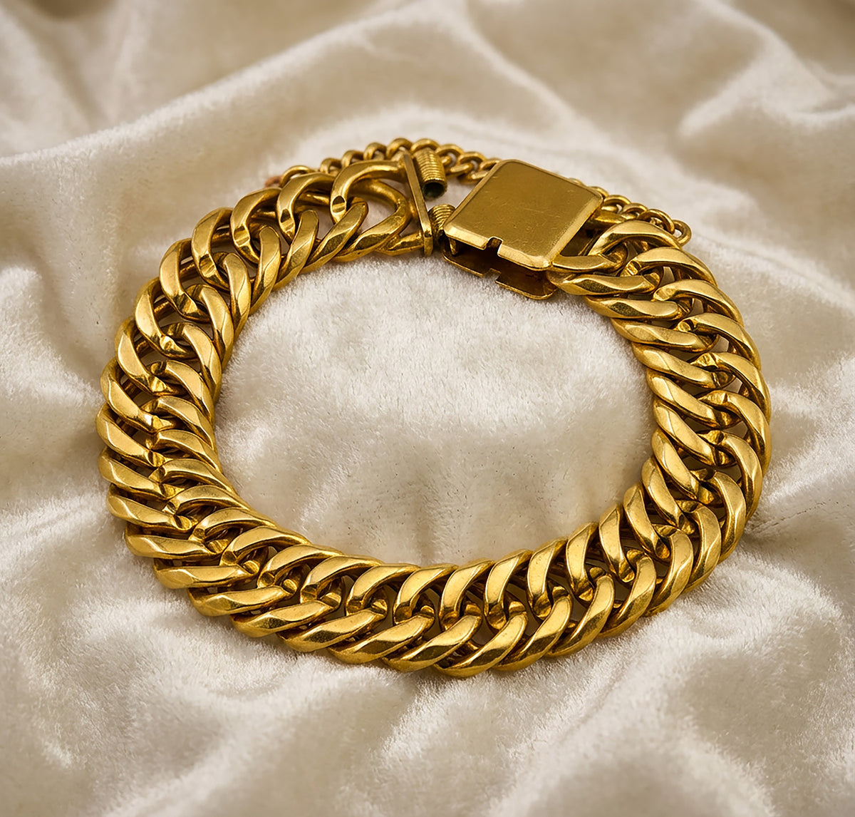 Handmade 22k yellow gold chain bracelet on white velvet.