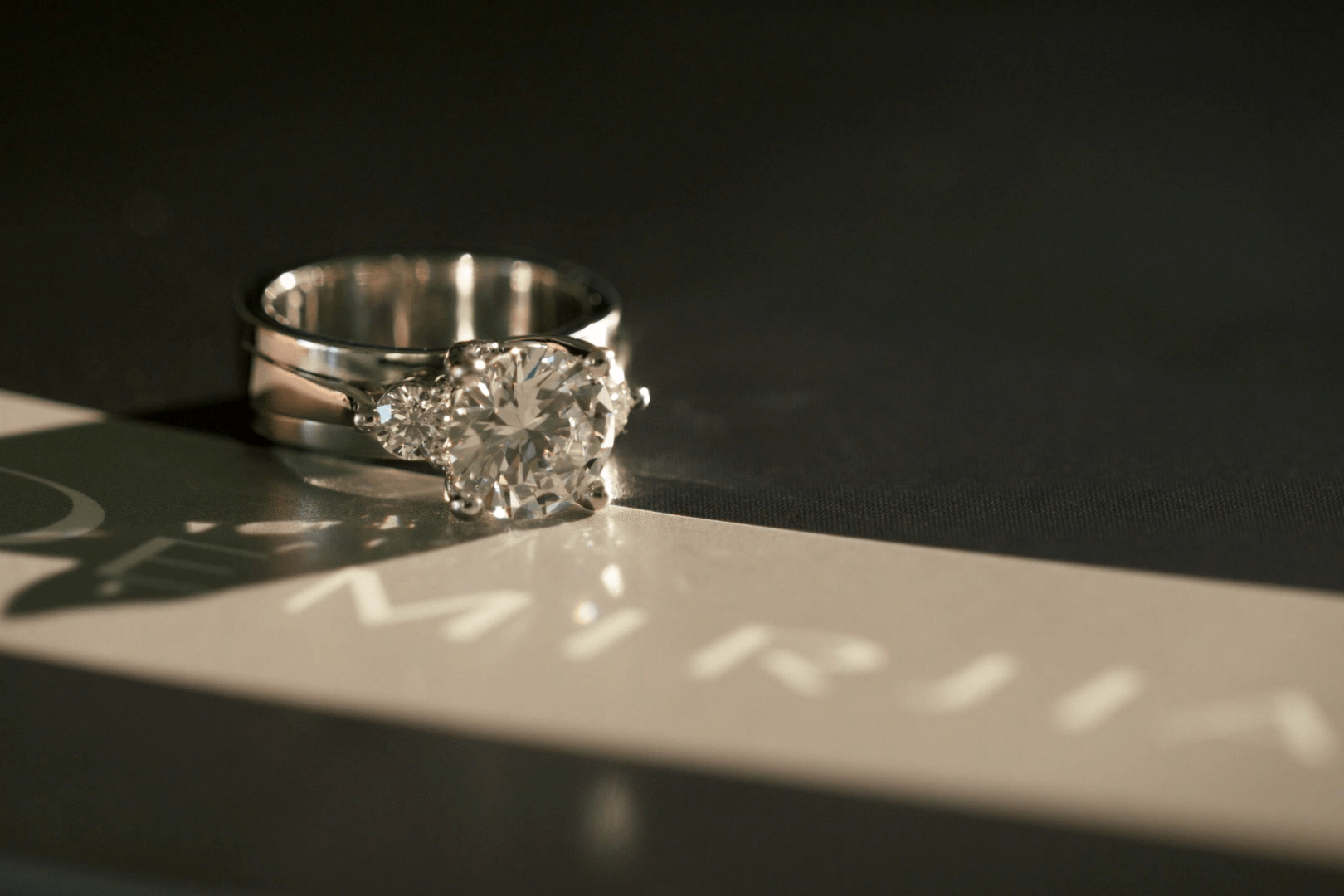 A diamond ring from Demirjian Jewelry Design, sitting on a table.