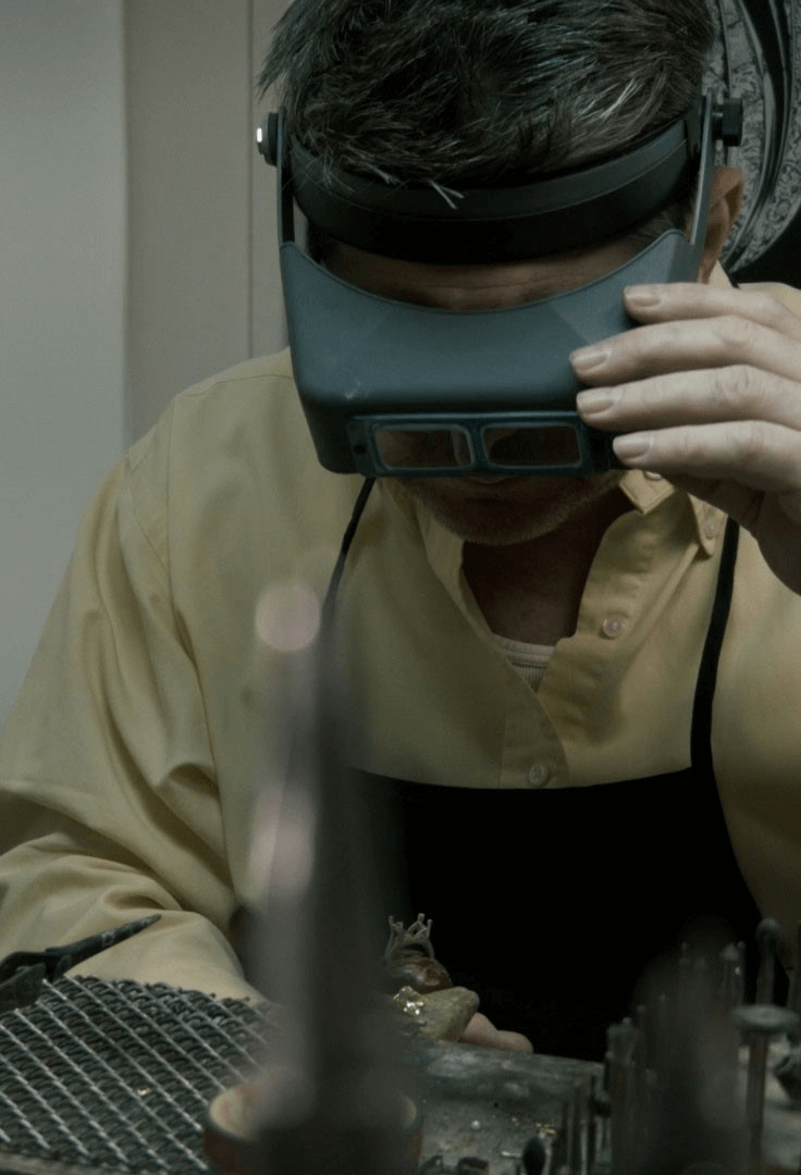 A super up close image of Garo Demirjian working on ring on a jewelry bench.
