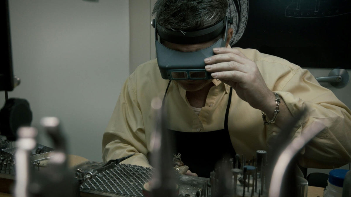 A close up of Garo Demirjian working on ring on a jewelry bench.