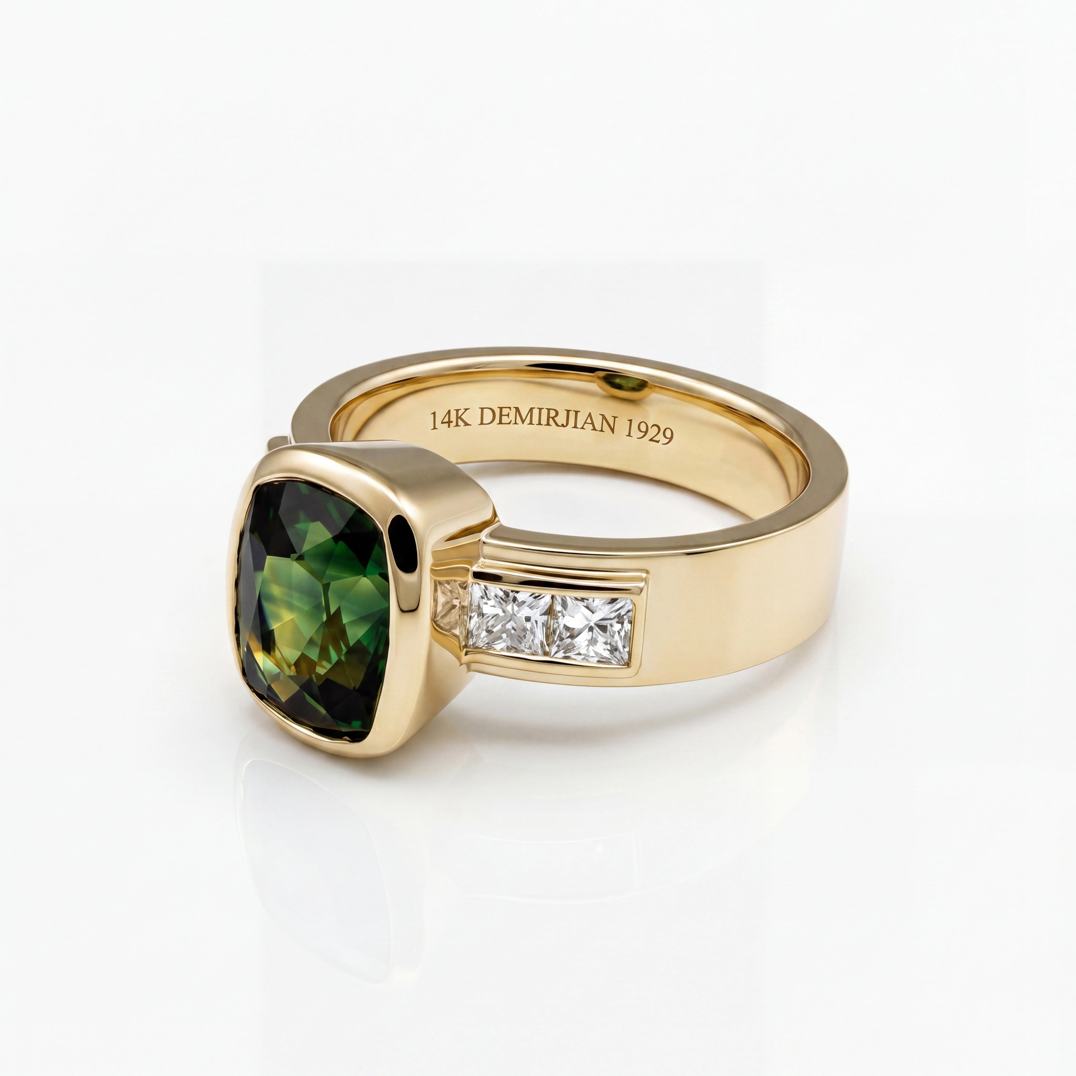 Custom engagement ring in 14k yellow gold featuring a green cushion-cut center stone with channel-set side diamonds.