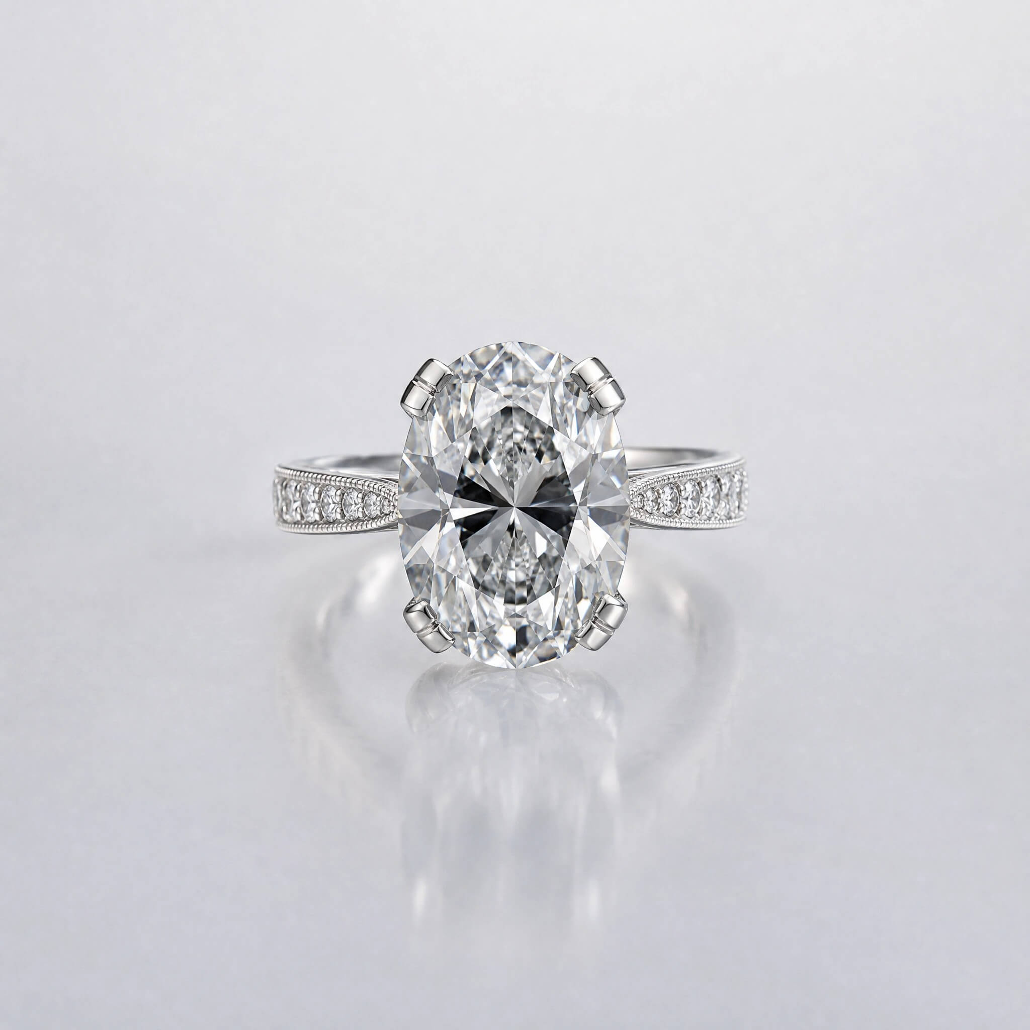 Custom oval cut diamond engagement ring in platinum with milgrain pavé detailing.